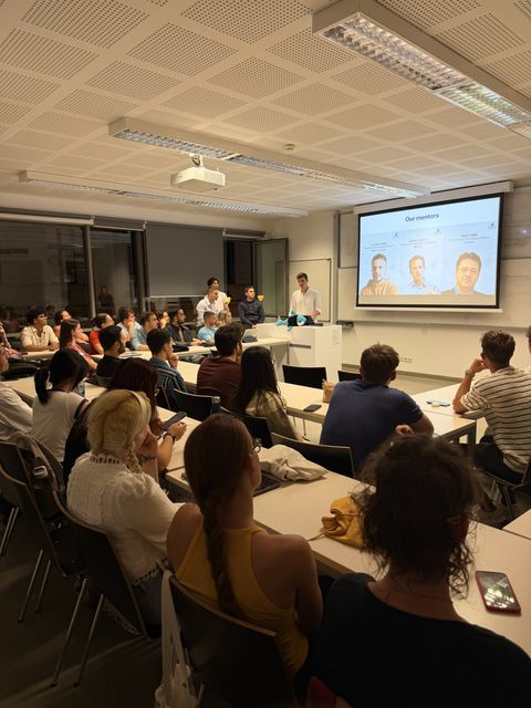 A full classroom listening to a presentation, with a slide on screen introducing ECC's mentors