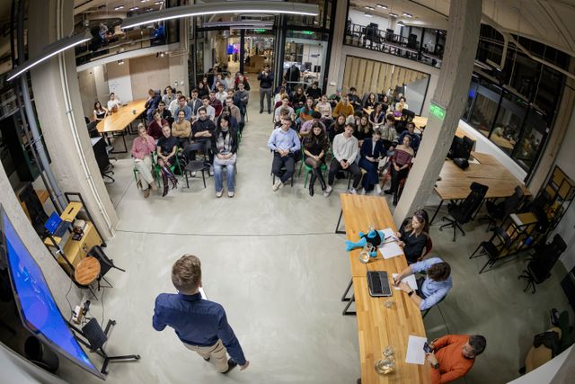 A founder pitching to a packed audience at Demo Day
